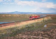 The Ghan train curving through South Australia’s outback with distant mountains
