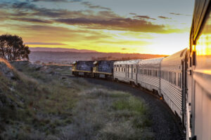 Indian Pacific train rounding a bend at sunset in scenic countryside of Bathurst.