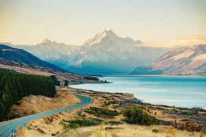 Winding road along Lake Pukaki leading to the snow-capped peak of Mount Cook in New Zealand’s South Island.