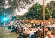 Guests enjoying an open-air group dinner with live music and fairy lights during the Great Southern journey.